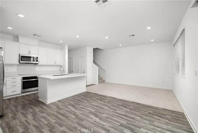 a view of kitchen with stainless steel appliances kitchen island sink refrigerator and stove