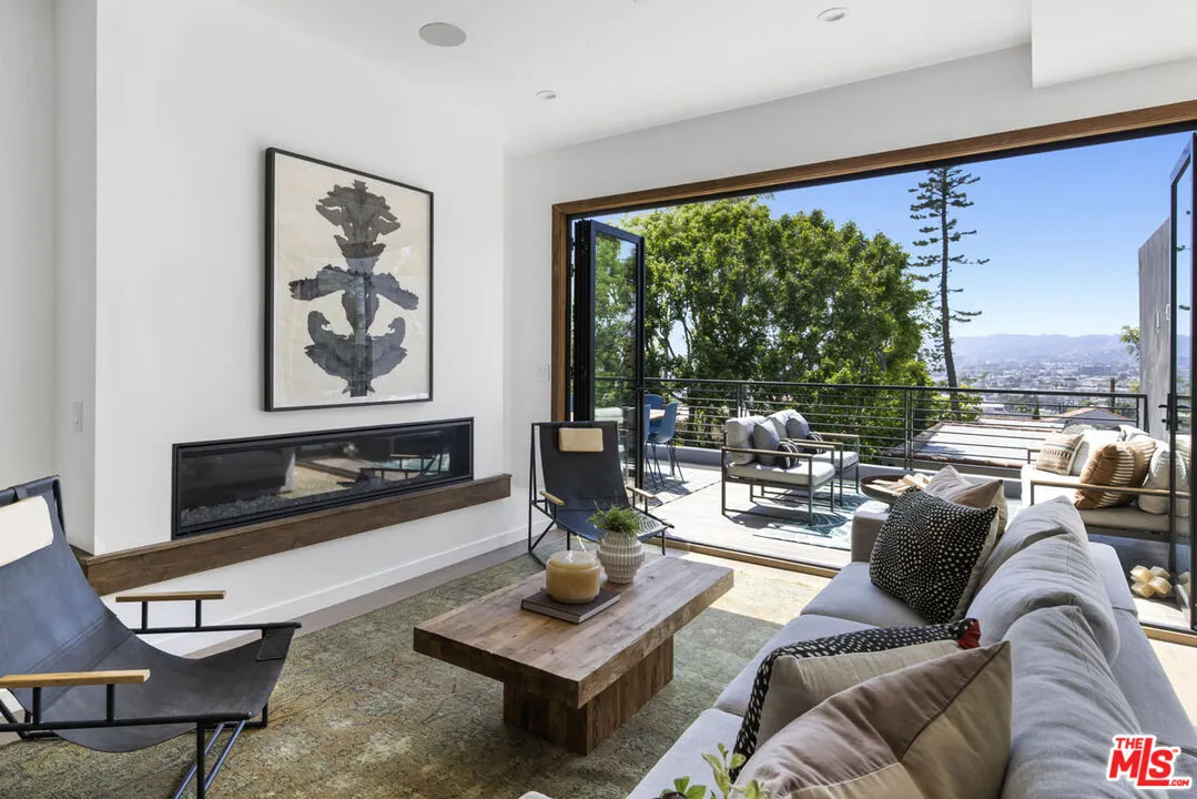 a living room with furniture large window and a flat screen tv