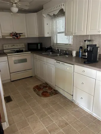 a kitchen with a sink a stove and cabinets