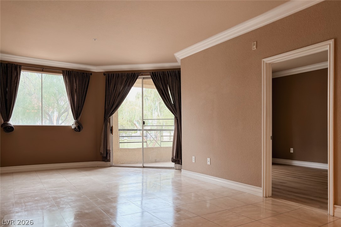 210 East Flamingo Road, Unit 112 Las Vegas, NV 89169 - Photo 4 of 59 Polished tile flooring and elegant crown molding elevate this open, light-filled living area.