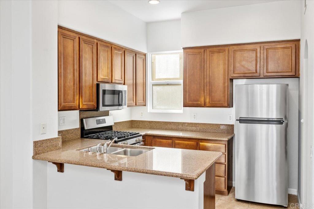 404 Almond Road San Marcos, CA 92078 - Photo 1 of 1 a kitchen with a refrigerator a stove and white cabinets