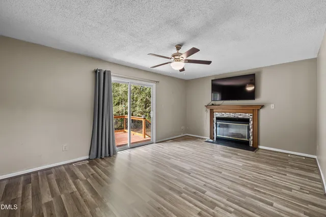 a view of an empty room with a fireplace and a window