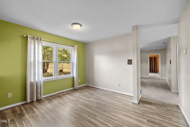 a view of an empty room with glass door and a window