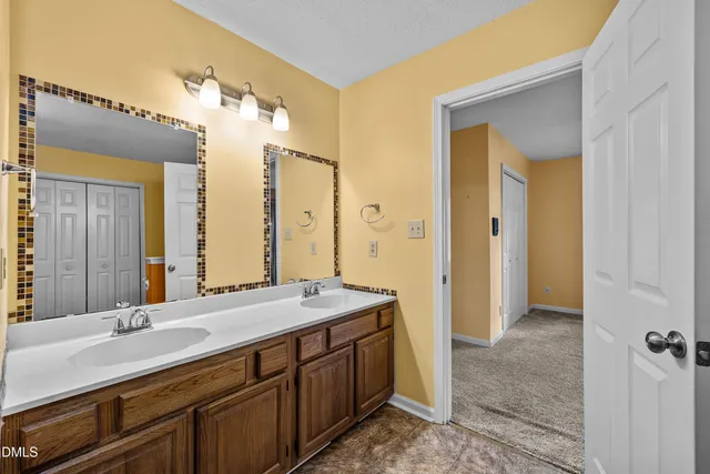 a spacious bathroom with a double vanity sink and a mirror