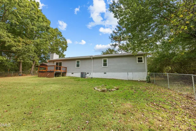 a backyard of a house with plants and large tree