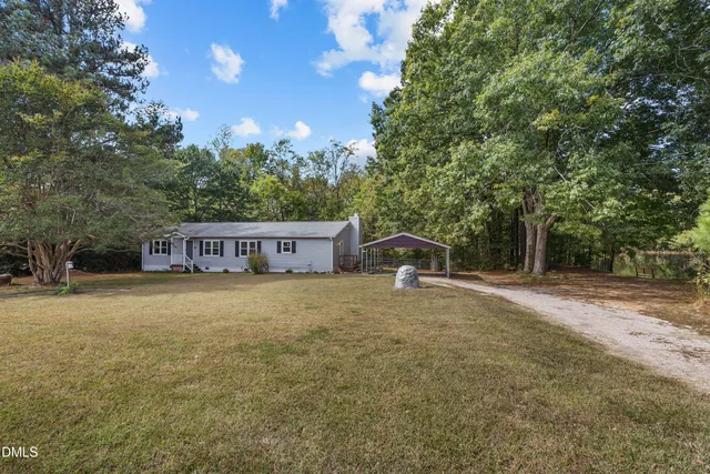 a front view of a house with yard and trees