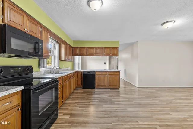 a kitchen with stainless steel appliances granite countertop a stove a sink and a refrigerator