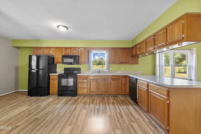 a kitchen with stainless steel appliances wooden floors and wooden cabinets
