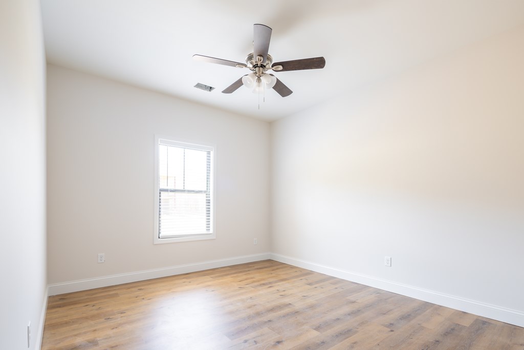 43 Lee Road Salem, AL 36874 - Photo 17 of 19 an empty room with wooden floor ceiling fan and windows