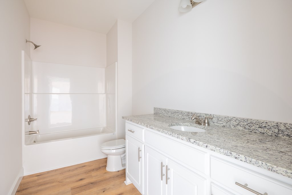 43 Lee Road Salem, AL 36874 - Photo 18 of 19 a bathroom with a granite countertop sink a toilet and shower