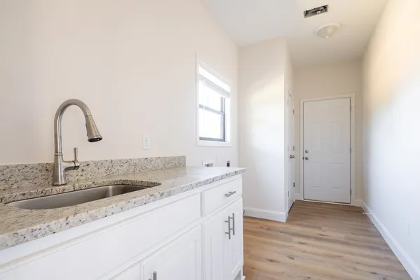 a kitchen with a sink and a wooden floor