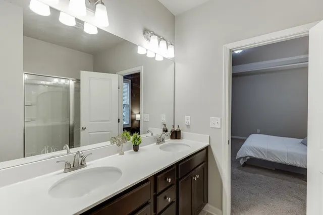 a en suite bathroom with a shower sink and mirror