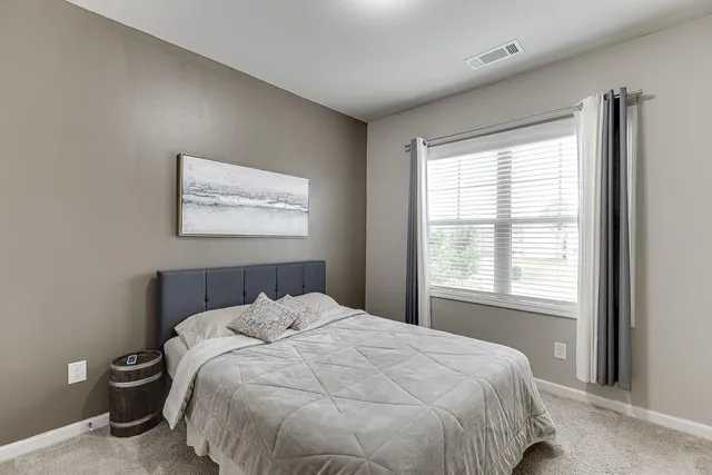 a bedroom with a bed and a painting on the wall