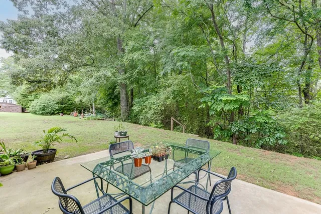 a backyard of a house with table and chairs