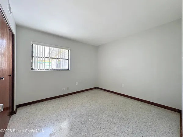 an empty room with windows and closet