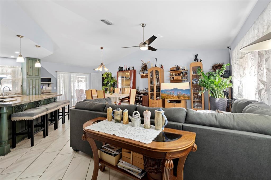 4307 Goldcoast Avenue Spring Hill, FL 34609 - Photo 13 of 53 a living room with furniture a chandelier and a dining table