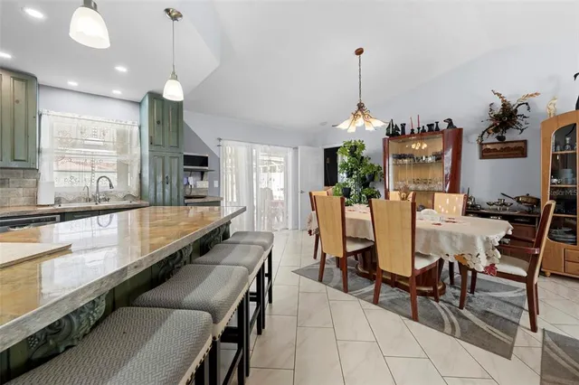 a dining room filled chandelier and wooden floor