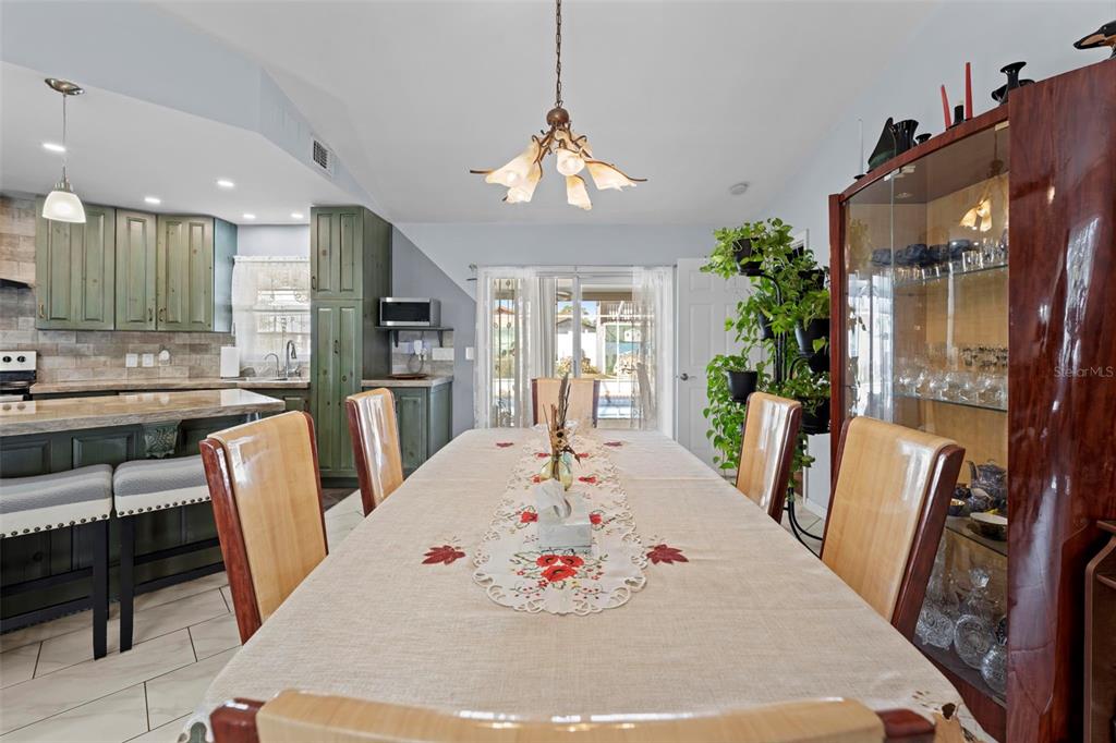 4307 Goldcoast Avenue Spring Hill, FL 34609 - Photo 19 of 53 a view of a dining room with furniture a chandelier and wooden floor