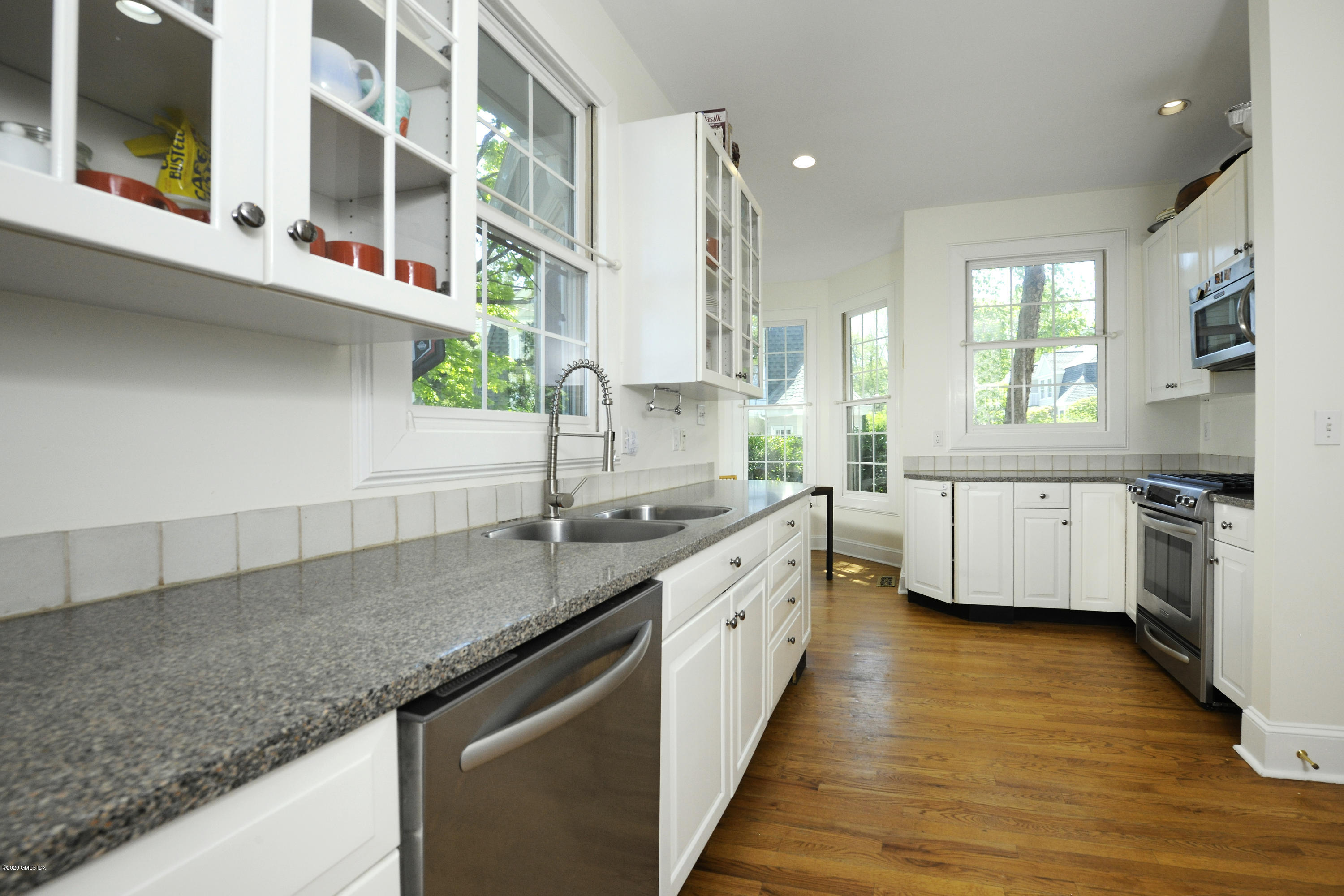 48 Spring Street, Unit 10 Greenwich, CT 06830 - Photo 5 of 11 a kitchen with stainless steel appliances granite countertop a sink a stove and a wooden floors
