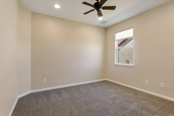 an empty room with a window and a fan