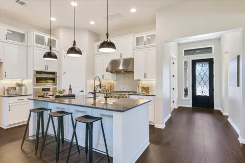 a kitchen with stainless steel appliances granite countertop wooden floors and stove
