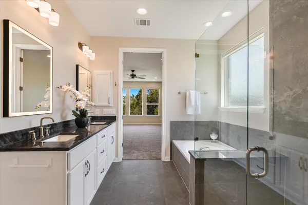 a spacious bathroom with a double vanity sink mirror and shower