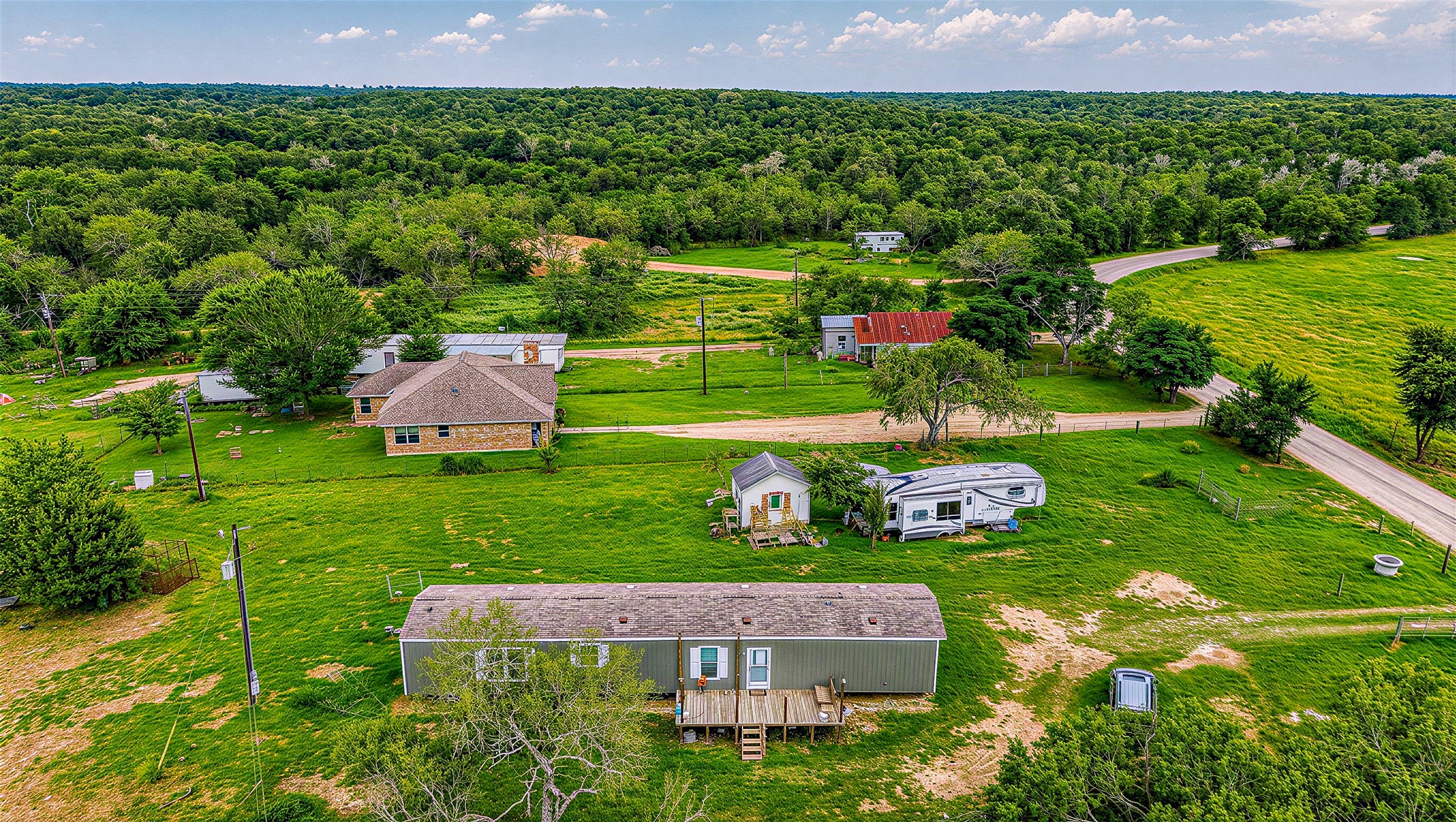 935 Lower Red Rock Road Bastrop, TX 78602 - Photo 25 of 25 Aerial view of sprawling grounds encompass this serene property featuring multiple structures and ample space.