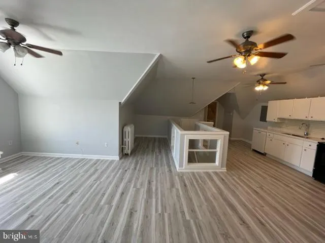 a view of a livingroom with a ceiling fan and wooden floor