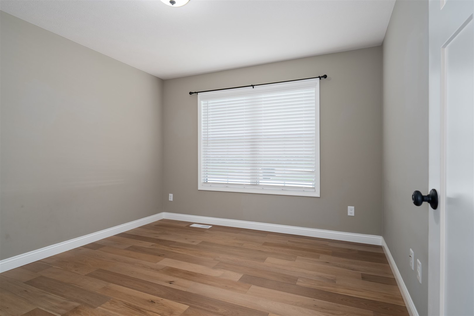1172 Hershey Road Normal, IL 61761 - Photo 4 of 37 a view of an empty room with wooden floor and a window
