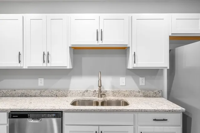 a kitchen with granite countertop a sink and cabinets