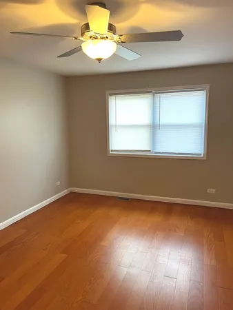 an empty room with a window and wooden floor