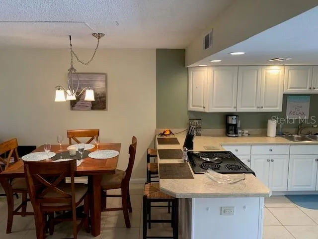 a kitchen with a table chairs and white cabinets