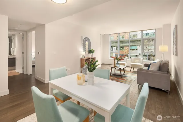 a kitchen with stainless steel appliances granite countertop a table chairs and a refrigerator