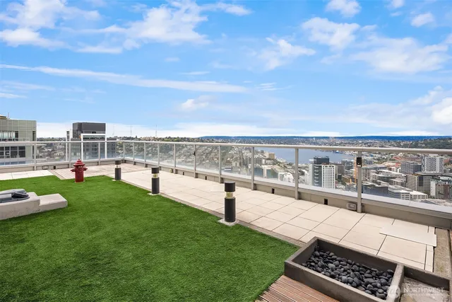 a view of a dining room with furniture a chandelier and large windows