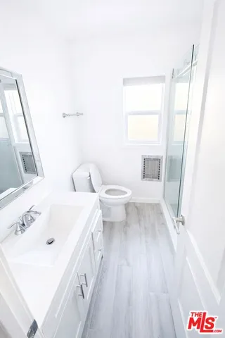 a bathroom with a sink a toilet and a mirror
