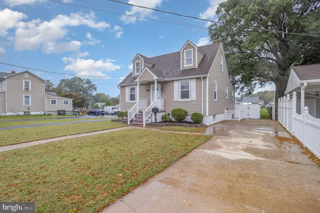 a view of a house with a big yard and large trees
