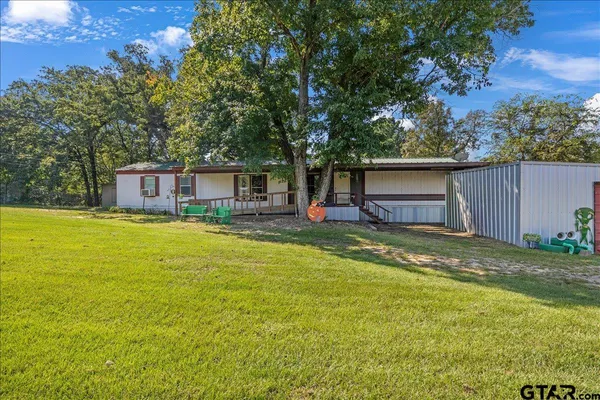 a view of a house with pool and a yard
