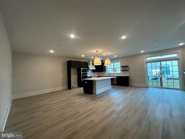 an open kitchen with kitchen island and stainless steel appliances
