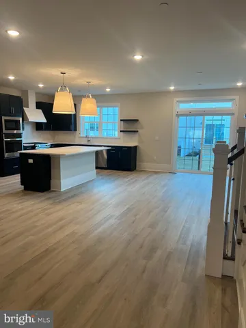 a large kitchen with stainless steel appliances granite countertop a large counter top a sink and a refrigerator