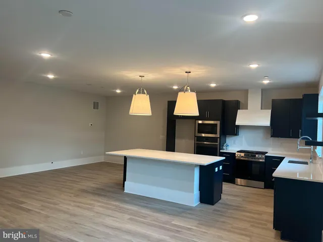 a view of kitchen with kitchen island sink and center island