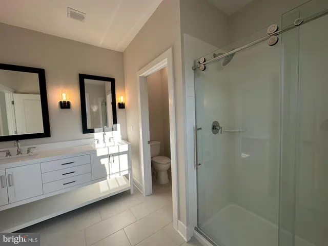 a bathroom with a shower sink and mirror