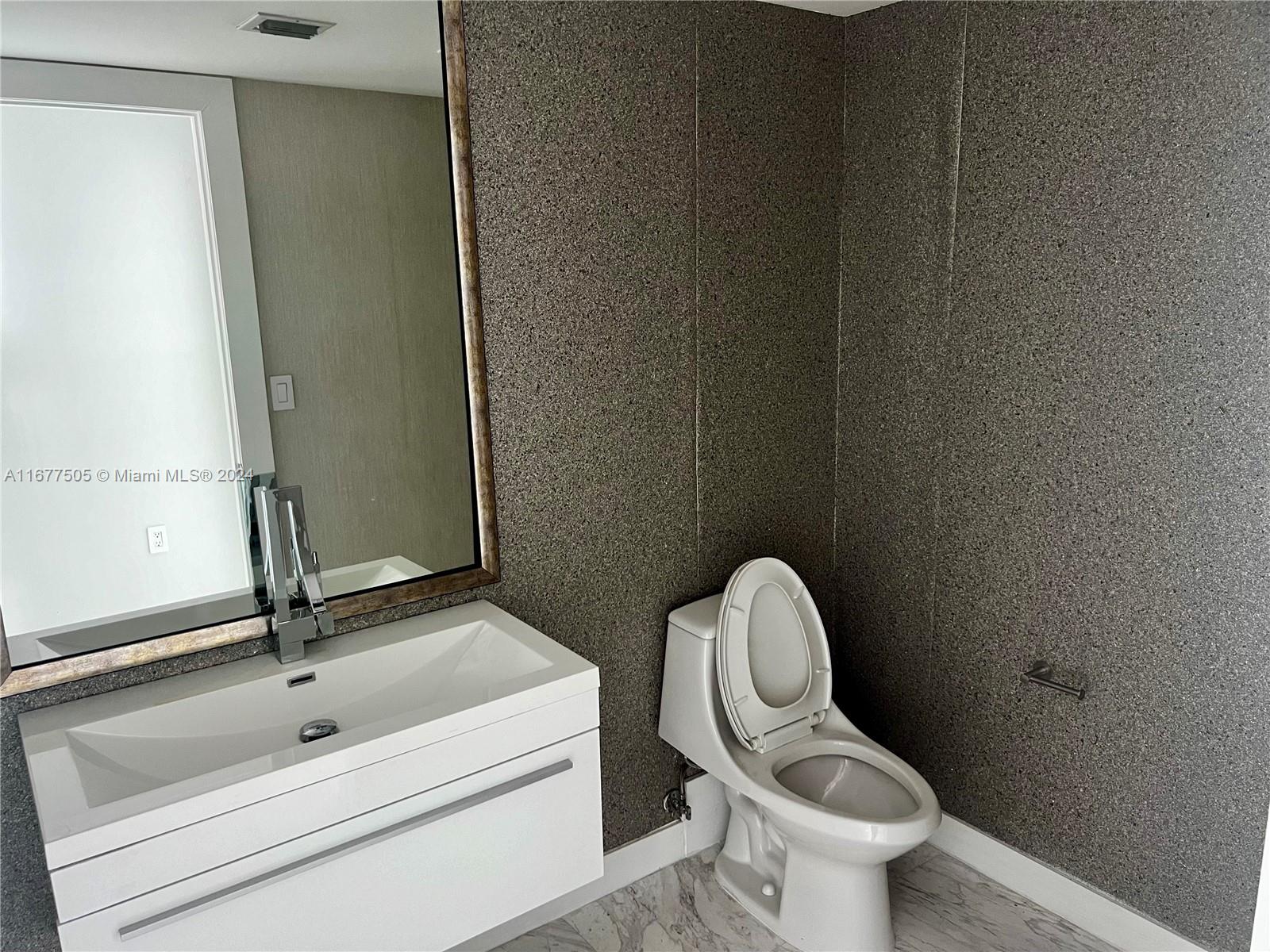 92 Southwest 3rd Street, Unit 3605 Miami, FL 33130 - Photo 14 of 24 a bathroom with a toilet sink and mirror