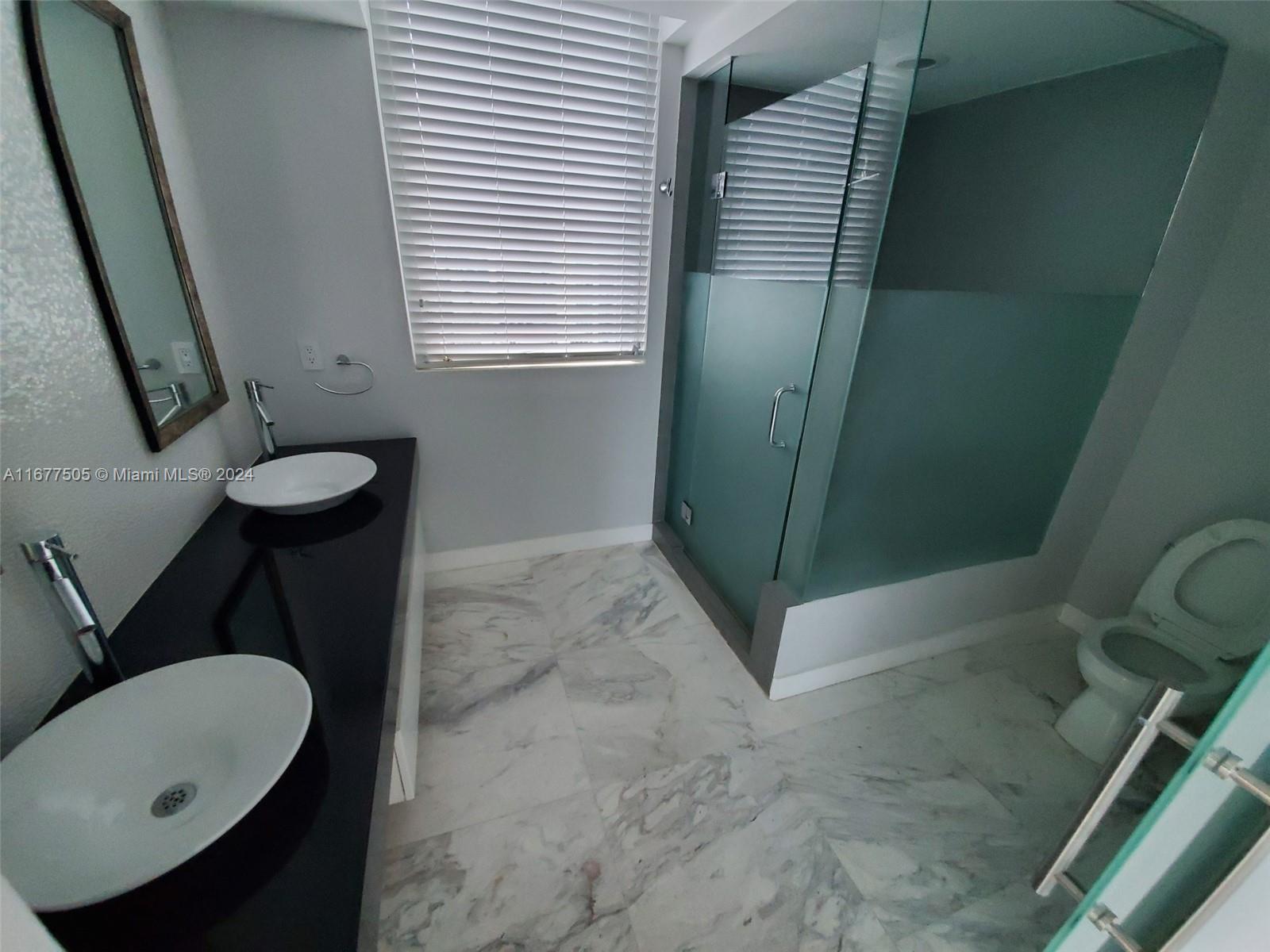 92 Southwest 3rd Street, Unit 3605 Miami, FL 33130 - Photo 17 of 24 a bathroom with a sink a toilet and a mirror