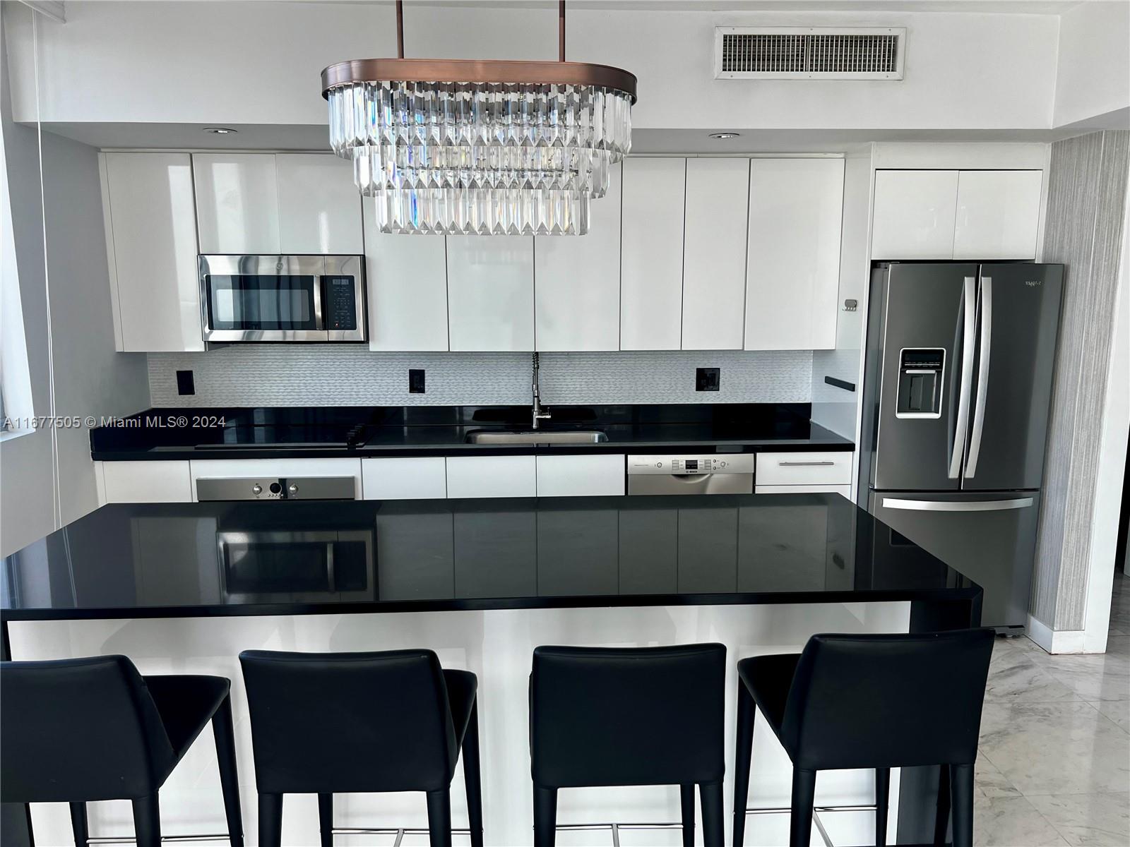 92 Southwest 3rd Street, Unit 3605 Miami, FL 33130 - Photo 8 of 24 a kitchen with a table chairs cabinets and stainless steel appliances