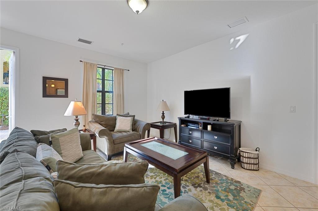 8945 Malibu Street, Unit 204 Naples, FL 34113 - Photo 3 of 21 a living room with furniture and a flat screen tv