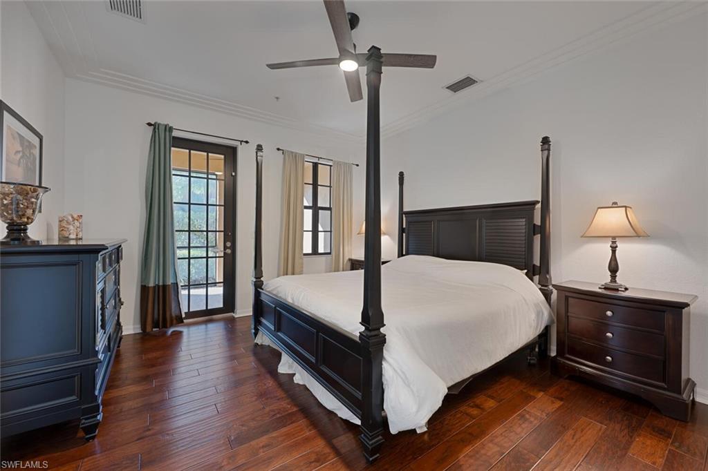 8945 Malibu Street, Unit 204 Naples, FL 34113 - Photo 7 of 21 a bedroom with a bed a chandelier and a window