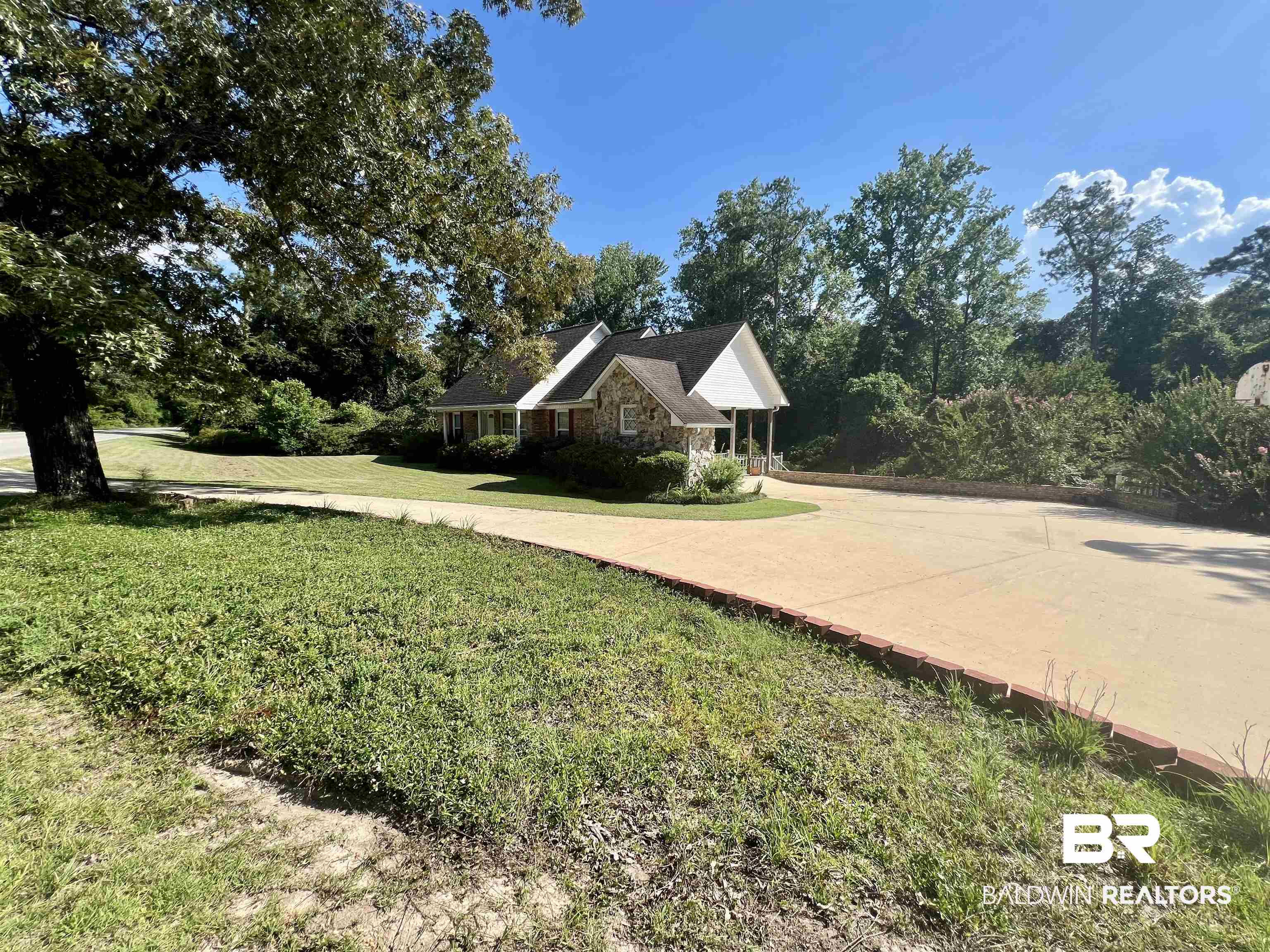 2691 Appleton Road Brewton, AL 36426 - Photo 55 of 60 View of side of home with stone siding, driveway, and a yard