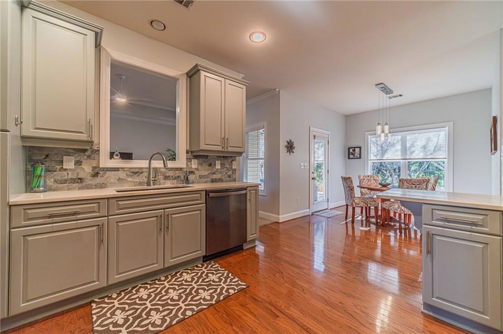 1245 White Columns Drive Monroe, GA 30656 - Photo 13 of 52 a kitchen with stainless steel appliances granite countertop a stove top oven a sink dishwasher a dining table and chairs with wooden floor