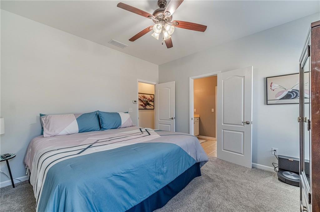 1245 White Columns Drive Monroe, GA 30656 - Photo 23 of 52 a bedroom with a bed and a chandelier