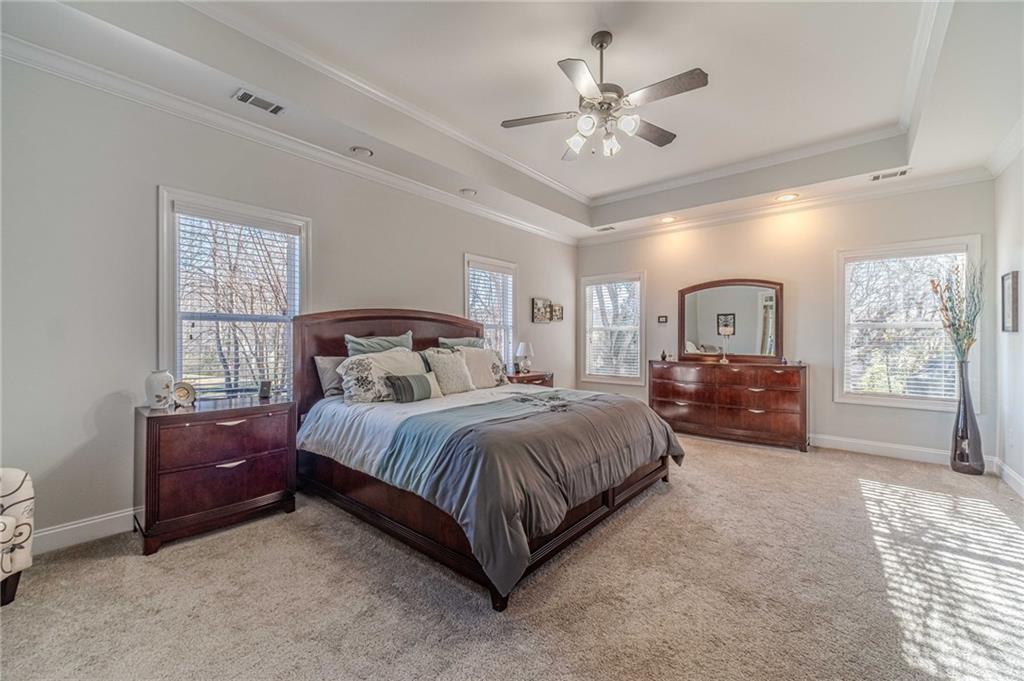1245 White Columns Drive Monroe, GA 30656 - Photo 26 of 52 a spacious bedroom with a large bed and a chandelier